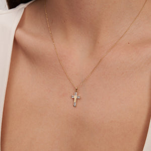 The 14K Solid Gold Tiny Minimal Cross Necklace, featuring a gold chain and a cross pendant embellished with small white gemstones, exudes elegance. The simple white background highlights its delicate design, making it a perfect piece of religious jewelry or a meaningful Christian faith gift.