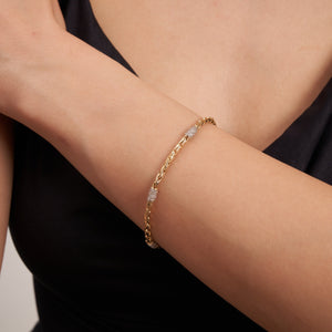 This handcrafted jewelry piece, named the 14K Solid Gold Wheat Palm Foxtail Link Bracelet CZ, showcases a twisted chain design in solid 14K gold and features four evenly spaced sections adorned with small, sparkling gemstones. The bracelet exudes a sleek and elegant appearance.