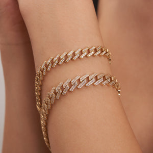 A 14K real gold Cuban link chain bracelet showcasing a thick, interlocking pattern adorned with cubic zirconia stones and featuring a rectangular, diamond-studded clasp.