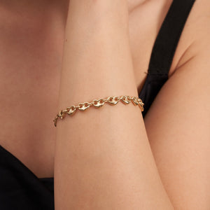 The 14K Real Gold Heart Shaped Mariner Bracelet beautifully showcases a series of linked heart-shaped elements, connected by smaller circular links that echo an anchor link chain design. Its elegant glisten stands out against a white background.