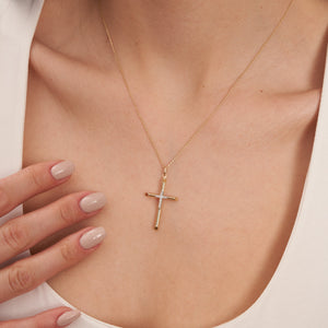 The 14K Real Gold Double Studded Cross Pendant Necklace CZ, featuring small diamonds at the intersection, hangs elegantly from a delicate chain. Ideal as a Christian faith gift, it is set against a white background to emphasize its exquisite craftsmanship.