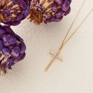 The 14K Real Gold Double Studded Cross Pendant Necklace CZ, featuring small diamonds at the intersection, hangs elegantly from a delicate chain. Ideal as a Christian faith gift, it is set against a white background to emphasize its exquisite craftsmanship.