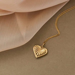 The 14K Gold Necklace features a mariner-inspired heart-shaped pendant with a 3D puffy sea shell design. This elegant pendant is complemented by a delicate gold chain.