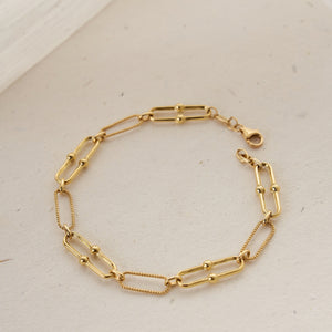 The 14K Real Solid Gold Paperclip Chain Bracelet features a beautiful design with alternating Italian paperclips and small round beads. Its rope-like textured links offer a chic and elegant look, all securely fastened with a lobster clasp.