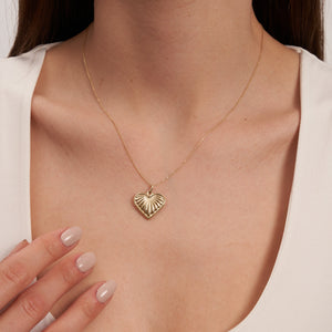 The 14K Gold Necklace features a mariner-inspired heart-shaped pendant with a 3D puffy sea shell design. This elegant pendant is complemented by a delicate gold chain.