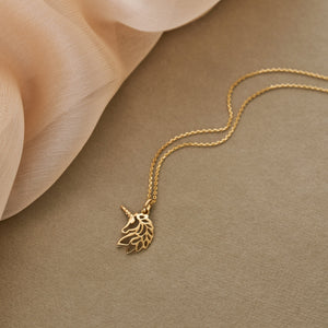 The 14K Solid Real Gold Unicorn Charm Pendant Necklace is a whimsical jewelry piece that features a delicate chain and a pendant intricately shaped like the silhouette of a unicorn's head, complete with an exquisite mane and horn.