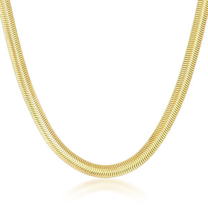 A close-up of the 14K Solid Gold Flat Herringbone Snake Chain Necklace, showcasing its sophisticated handmade design that elegantly reflects light. The necklace gently curves to emphasize its polished, shiny surface against a white backdrop.