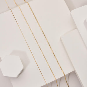 Displayed against a white background, the 14K Solid Gold Box Chain Necklace is a delicate piece with dainty, square-shaped links forming a continuous loop.