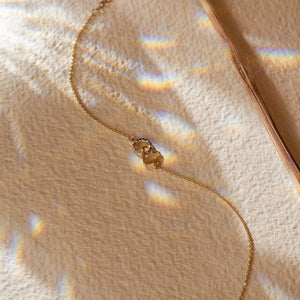 The 14K Solid Gold Minimal Heart and Circle Interlocking Bracelet highlights a delicate design with heart-shaped and circular pendants, the latter adorned with small white stones. This handmade jewelry piece features an adjustable chain and a lobster clasp closure.