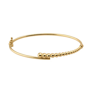 The 14K Solid Gold Bead Bangle Bracelet showcases a chic, minimalist design featuring a row of spherical beads ascending in size along the band. Ideal for enthusiasts of stackable jewelry, it seamlessly enhances any collection.