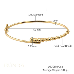 The 14K Solid Gold Bead Bangle Bracelet showcases a chic, minimalist design featuring a row of spherical beads ascending in size along the band. Ideal for enthusiasts of stackable jewelry, it seamlessly enhances any collection.