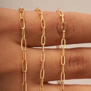 The 14K Solid Gold Paperclip Chain Necklace, featuring elongated oval links and showcased against a white background, epitomizes minimal dainty jewelry.