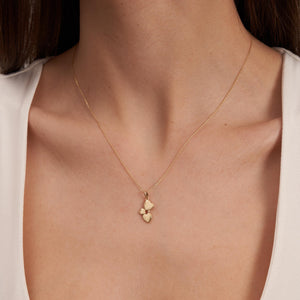 The 14K Solid Gold Minimal Heart Pendant Necklace showcases three interconnected heart shapes in varying sizes, intricately crafted in solid gold. This elegant pendant is suspended from a delicate gold chain, exuding simplicity and sophistication.