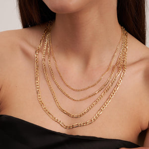 A detailed view of the 14K Solid Gold Figaro Chain for Women & Men, highlighting its interlocking oval and round links. Set against a white background, the hypoallergenic chain exhibits a sleek and polished shine.