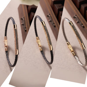 This elegant men's accessory, known as the 14K Solid Gold Men's Greek Key Bracelet, features a stylish twisted black cable band with a 14K solid gold clasp. It is highlighted by a gold bar adorned with small, dark stones arranged in a sophisticated linear pattern.