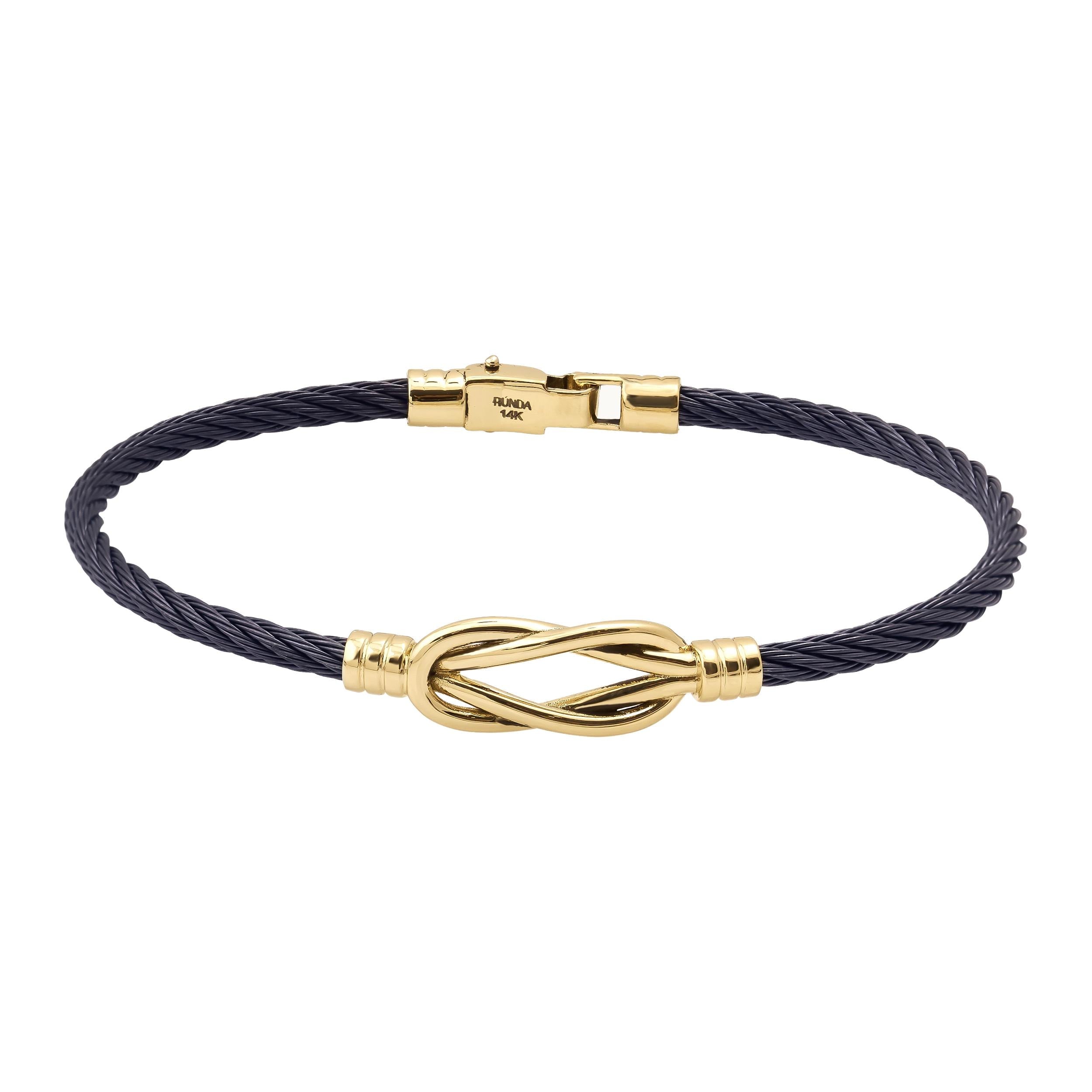 Introducing the 14K Solid Gold Knot Bracelet for Men, featuring a modern and elegant design with a sleek stainless steel bangle. It showcases a black twisted cable band accented by a central gold knot and is secured with a gold clasp.