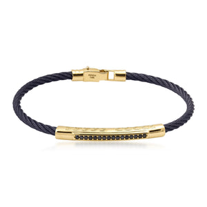 This elegant men's accessory, known as the 14K Solid Gold Men's Greek Key Bracelet, features a stylish twisted black cable band with a 14K solid gold clasp. It is highlighted by a gold bar adorned with small, dark stones arranged in a sophisticated linear pattern.