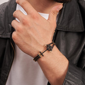 Introducing the 14K Real Solid Gold & Braided Leather Anchor Black Cord Bracelet for Men: A chic bracelet that combines a braided black leather strap with luxurious gold details, including a prominent studded anchor centerpiece. It also features a secure clasp and offers customizable chain sizing for an ideal fit.