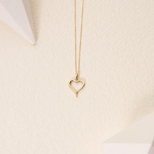 The 14K Solid Gold Diamond Open Heart Necklace for Women showcases a delicate open heart-shaped pendant adorned with a natural diamond accent, elegantly hanging from a thin chain against a plain white background.