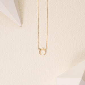 The Diamond Crescent Moon Pendant Necklace in 14K Solid Gold is a refined piece crafted from authentic gold. It showcases a crescent moon pendant embellished with tiny natural diamonds. The slender, graceful chain beautifully accentuates the moon's design, providing an essence of sustainable jewelry luxury.