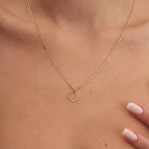 The 14K Solid Gold Real Diamond Open Teardrop Necklace for Women showcases an elegant pendant in the shape of a looped ribbon, embellished with natural genuine diamonds at the bottom. It hangs gracefully on a delicate chain, blending fine handcrafting with minimalist design to capture light for a subtle sparkle.