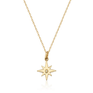 This eco-friendly jewelry item is the Diamond North Star Necklace in 14K Gold for Women. It includes a fine gold chain with a star-shaped pendant, which features a polished surface and is adorned with a natural diamond at its center, offering an elegant sparkle.