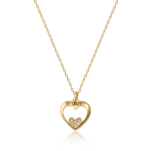 The Real Diamond Heart Necklace in 14K Gold features a delicate design with a heart-shaped pendant. Inside this stunning pendant, a smaller heart sparkles with natural diamonds. The elegant gold chain elegantly drapes against the white backdrop, exuding sophistication and allure.