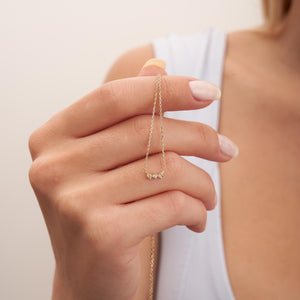 The Natural Diamond Solid 14K Minimal Dainty Trio Necklace is an elegant piece, showcasing a thin chain made from solid gold and accented at the center with three small natural diamond stones set closely together.