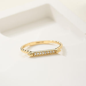 A 14K Solid Gold Twisted Diamond Wedding Band featuring a horizontal bar decorated with small, sparkling natural diamonds.