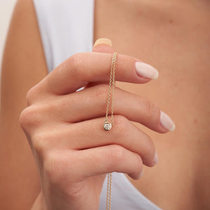 The 14K Solid Gold Diamond Solitaire Bezel Necklace is a beautifully crafted piece featuring a round, bezel-set diamond pendant. Made with genuine diamonds and set on a 14K solid gold fine chain, this necklace exudes simplicity and elegance, making it ideal for both everyday use and formal occasions.