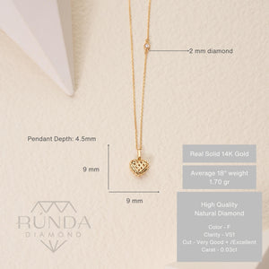 The Real Diamond 3D Puffy Heart Necklace in 14K Gold showcases a heart-shaped pendant on a chain. Crafted from solid gold, the pendant features an open lattice design, offering a delicate and elegant look. The genuine gold's luxury is beautifully highlighted against a white background.