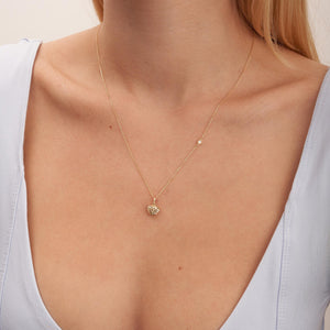 The Real Diamond 3D Puffy Heart Necklace in 14K Gold showcases a heart-shaped pendant on a chain. Crafted from solid gold, the pendant features an open lattice design, offering a delicate and elegant look. The genuine gold's luxury is beautifully highlighted against a white background.