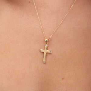 A 14K Solid Gold Diamond Cross Necklace featuring a genuine gold chain and a cross pendant. The elegantly designed cross has a smooth finish with small natural diamonds adorning each of its four ends, while the finely linked, delicate chain exemplifies sustainable jewelry craftsmanship.