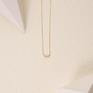 The Natural Diamond Solid 14K Minimal Dainty Trio Necklace is an elegant piece, showcasing a thin chain made from solid gold and accented at the center with three small natural diamond stones set closely together.