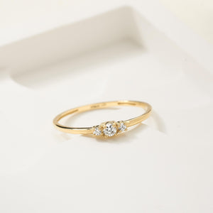 The 14K Solid Gold Diamond Promise Ring features a slim band with three round, sparkling natural diamonds set centrally, highlighting the brilliance of the stones in its simple yet elegant design.