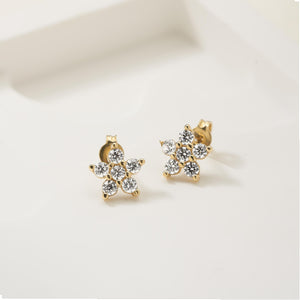 A pair of 14K solid gold earrings shaped like flowers, each studded with natural diamonds. The set includes a front view showing the flower design and a side view displaying the post and butterfly clasp.