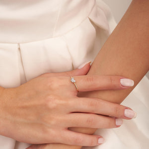 The 14K Solid Gold Natural Diamond Heart Engagement Ring showcases a heart centerpiece with small natural white diamonds, set elegantly on a thin band against a plain white backdrop.