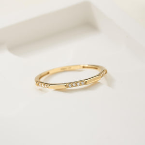 The 14K Solid Gold Geometric Diamond Ring for Women is a delicate piece crafted from genuine gold, showcasing small, sparkling natural diamonds along the band against a white background.