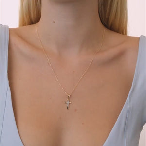 The 14K Solid Gold Diamond Tiny Cross Necklace showcases a cross pendant embellished with natural diamonds.