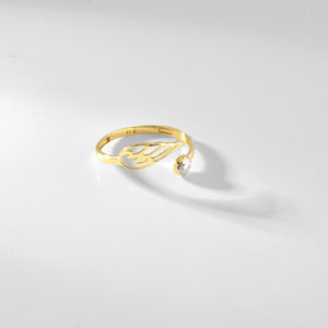 The Angel Wing Ring in 14K Gold showcases an open, abstract leaf design reminiscent of angel wings, elegantly encircling a small, round silver element. The hypoallergenic gold and silver blend adds a modern and sophisticated touch.