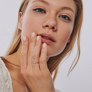 The 14k Solid Gold Knot Ring features a twisted band and is set against a white background, highlighting its simple and elegant design. Perfect as a minimalist stackable gold ring, it effortlessly captures timeless beauty.