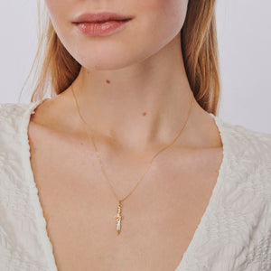 Introducing the 14K Solid Gold Sword Necklace, a stunning jewelry piece with a delicate chain and an elegant sword-shaped pendant. This hypoallergenic necklace features intricate designs adorned with subtle cubic zirconia embellishments. Its beauty is accentuated against a simple white background.