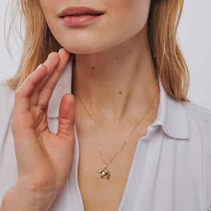 Introducing the 14K Solid Gold Elephant Necklace, featuring a minimalist design with a delicate gold chain and an exquisitely crafted elephant-shaped pendant. The polished finish of the elephant gleams beautifully, making this necklace a charming good luck charm to enhance your personal style.