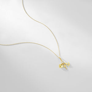 The Faith Hope Love Necklace is a 14K Gold Necklace adorned with a Cross Charm Pendant along with heart and anchor charms, representing faith, hope, and love. Each charm gracefully hangs from a delicate gold chain set against a pristine white background.