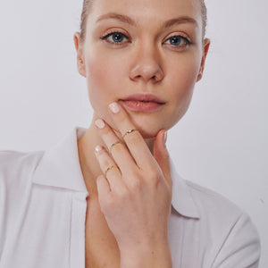 Introducing the 14K Solid Gold Minimalist Stacking Ring, a simple and elegant piece featuring a smooth, thin band with sides adorned in small, round bead-like designs. Its polished surface makes it ideal for sophisticated style and those who appreciate dainty elegance.