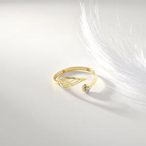 The Angel Wing Ring in 14K Gold showcases an open, abstract leaf design reminiscent of angel wings, elegantly encircling a small, round silver element. The hypoallergenic gold and silver blend adds a modern and sophisticated touch.