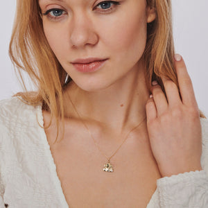 A delicate 14K gold necklace featuring a pendant of a cat family, expertly crafted in shining metal.