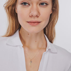 The 14K Gold Angel Wing Pendant Charm Necklace features a captivating angel wing pendant with an eye motif at its center, elegantly suspended from a delicate chain against a pristine white backdrop. This necklace is hypoallergenic and radiates elegance.