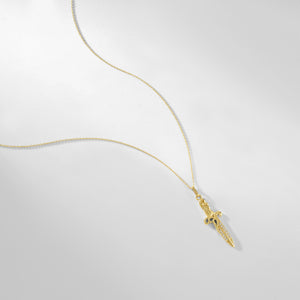 Introducing the 14K Solid Gold Sword Necklace, a stunning jewelry piece with a delicate chain and an elegant sword-shaped pendant. This hypoallergenic necklace features intricate designs adorned with subtle cubic zirconia embellishments. Its beauty is accentuated against a simple white background.