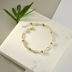 The 14K Gold Evil Eye Bracelet features a delicate design with alternating small blue evil eye charms and oval links. This elegant protection bracelet is secured with a lobster clasp.